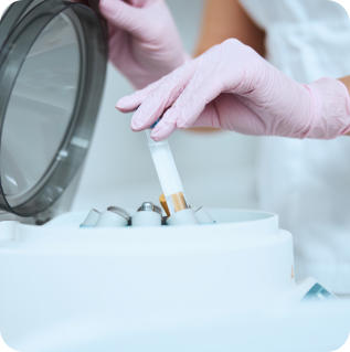A doctor removes a tube from a centrifuge to use in a platelet-rich plasma therapy treatment